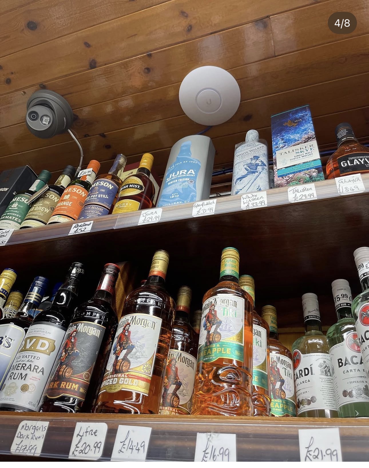 UniFi access point and CCTV camera installed above the spirits shelf in Mulholland's Off Sales